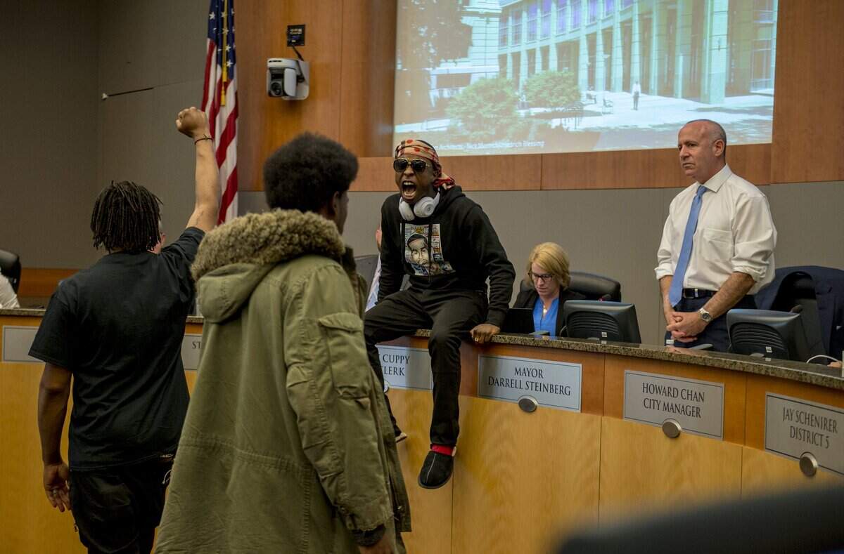 Stevante Clark, whose brother Stephon Clark was fatally shot by Sacramento police, sits on the City Council dais in front of then-Mayor Darrell Steinberg, briefly forcing the council to call a recess, in 2018.